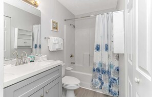 A bathroom with a shower, toilet, sink, and a mirror. - Waterway Village 12E (Myrtle Beach)