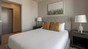 A hotel room with a large bed, two bedside tables, a headboard, and a framed picture on the wall. - Landing | Incredible 1BD, Clubhouse (Portland)