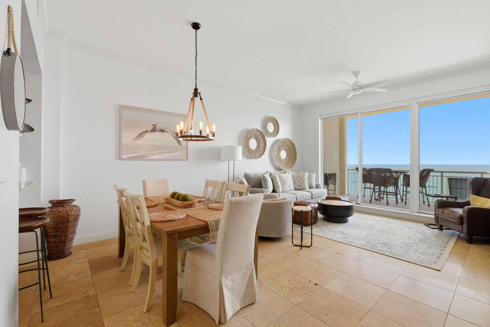 Un vaste espace de vie comprenant une table à manger, des chaises, un canapé et un balcon avec vue.