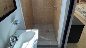 Ein Badezimmer mit Dusche, Waschbecken und einem Fenster.