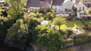 Un quartier résidentiel avec des maisons, une pelouse et un plan d’eau.