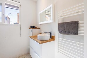 A bathroom with a white sink, a mirror, and a towel rack. - Valras-Plage Renovated House w/ Terrace, Close (Valras-Plage)