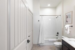 A bathroom with a shower, toilet, and vanity. - Landing | Spectacular 1BD, Clubhouse, Gym (Denton)