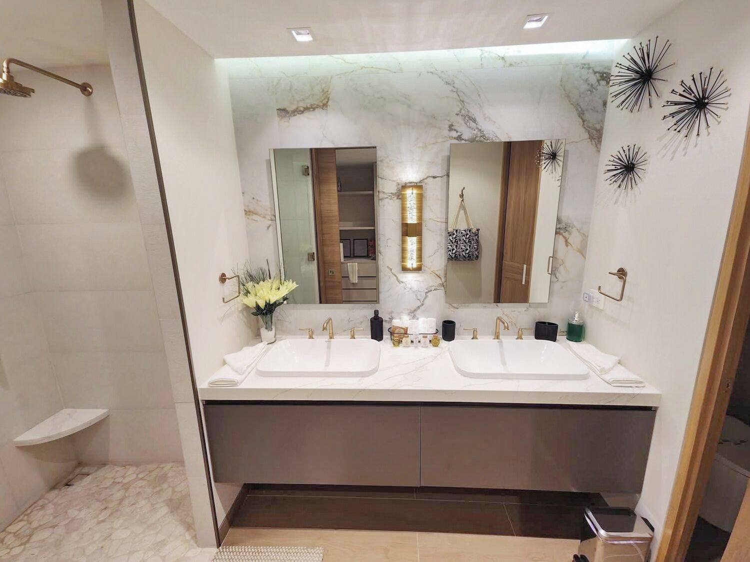 Un baño moderno con dos lavamanos, ducha y tocador con espejo.