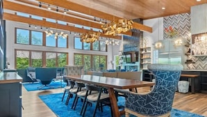 Un comedor moderno con una mesa de madera, sillas estampadas en azul y una alfombra azul.