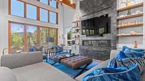 Un salón espacioso con chimenea, ventanas amplias y balcón.
