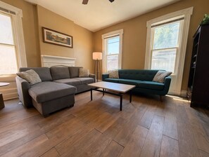 A living room with a sectional sofa, a coffee table, and a fireplace.