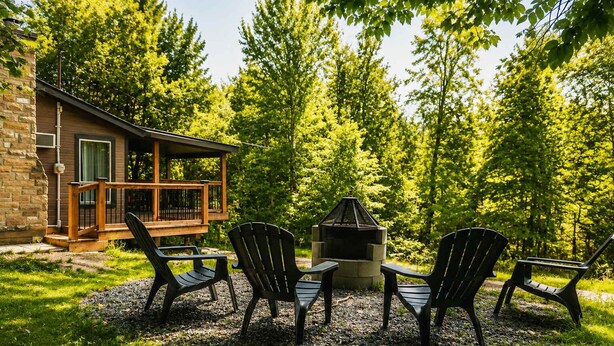 A cabin with a deck, a fire pit, and three Adirondack chairs. - Escape in the heart of Miller Zoo | Sheira Shack (Frampton)