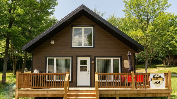A lodge with a wooden exterior, a front porch, and a sign indicating it is a 'Luna Nuage' accommodation. - River & Miller Zoo | Louna-Nuage Shack (Frampton)
