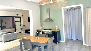 Una cocina moderna con comedor, estufa integrada y lámpara colgante.