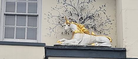 A building facade with a decorative sculpture of a horse and a tree.