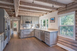 A modern kitchen with stainless steel appliances, light gray cabinetry, and a wooden floor. - The Anderson - Calistoga , Pool, Near Vineyards (Calistoga)