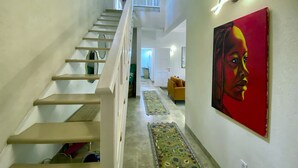 Eine Treppe mit Handlauf, ein Gemälde an der Wand und ein Teppich auf dem Boden.