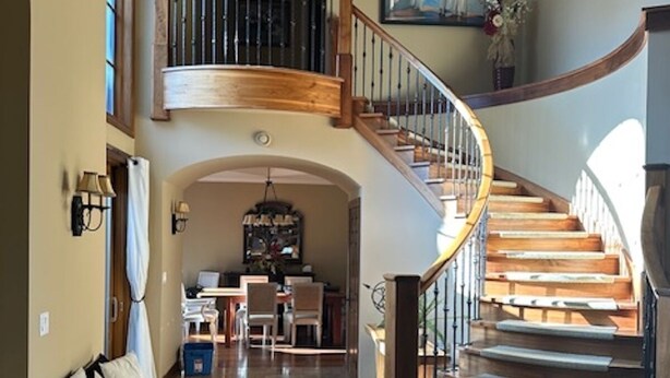 A spacious foyer with a grand staircase, a dining area, and a chandelier. - High-End Waterfront Estate in Stratford | Relax, Unwind, Enjoy Views (Stratford)