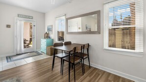 A dining area with a table and chairs, a ceiling fan, and a door labeled "BEACH". - Steps to Beach! Sleeps 8 + pool + garage+ beach gear + lagoon fishing + 2 patios (Panama City Beach)