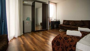 Une chambre d’hôtel avec un lit, un canapé, un bureau et un miroir.