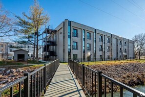 A modern building with a covered walkway leading to a gated entrance. - Landing | Spectacular 2BD, Courtyard, Gym (Nashville)