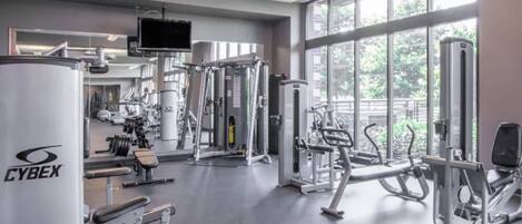 Un gimnasio con equipo de ejercicio diverso, ventanas amplias y una máquina Cyrex.