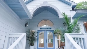 A house with a blue door labeled 'Serenity Now,' a covered porch, and potted plants. - Bayfront Retreat on 1.5 Acres - Private Dock - 4BR Near Destin (Freeport)