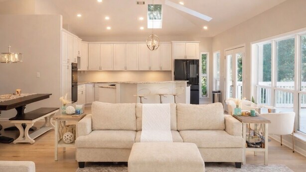 A spacious living area with a sofa, a dining table, and a kitchen in the background. - Bayfront Retreat on 1.5 Acres - Private Dock - 4BR Near Destin (Freeport)