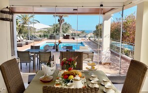 Ein Essbereich mit Blick auf einen Pool und Sitzmöglichkeiten im Freien.