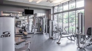 Uma academia com diversos equipamentos de exercício, amplas janelas e uma máquina Cyrex.