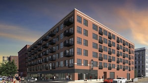 A multi-story building with a brick facade, multiple balconies, and large windows. - Landing | Beautiful 2BD, Courtyard, Gym (St. Louis)