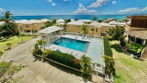 Ein Resort mit Swimmingpool, Palmen und Meerblick.