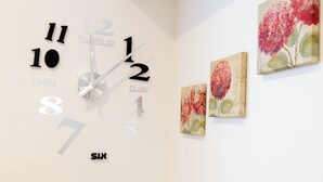 Een wandklok met cijfers en een woord uit zes letters.