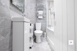 A modern bathroom with a toilet, sink, and shower. - Brighton Central Elegant Stays, Walk to the Beach (Brighton and Hove)