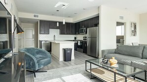 A modern apartment with a living room, kitchen, and dining area. - Landing | Stylish 2BD, Gym, Yoga Studio (Palmetto)