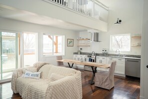A spacious living area with a high ceiling, a dining table, and a cozy seating area. - Steps to Lake Como! Intimate Getaway Lake Geneva! (Lake Geneva)