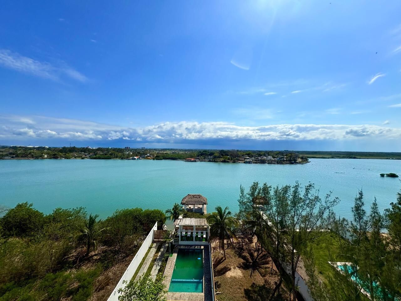 A resort with a pool, a gazebo, and a view of a large body of water.