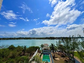 Una piscina al aire libre, sombrillas, sillones reclinables de piscina
