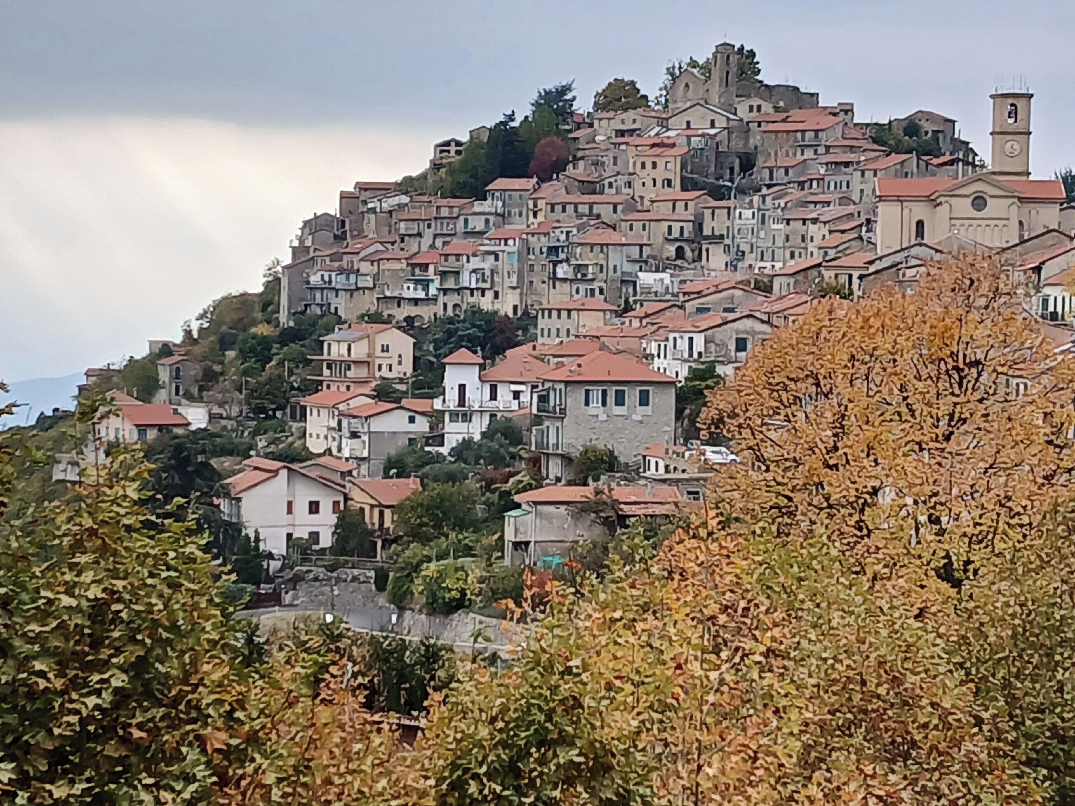 A hillside town with historic buildings, a prominent church, and a clock tower.