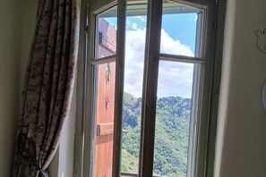 A window with a view of a forested area. - Elegant Bajardo Apartment With Stunning Views (Bajardo)