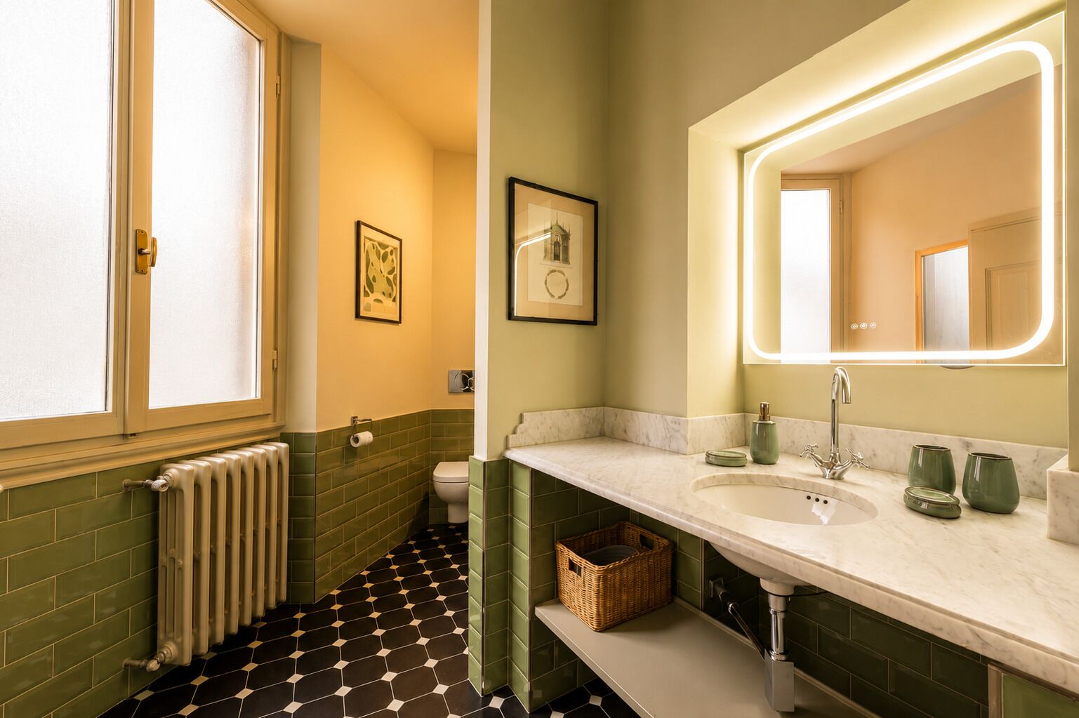 Et badeværelse med toilet, håndvask, spejl og en radiator.