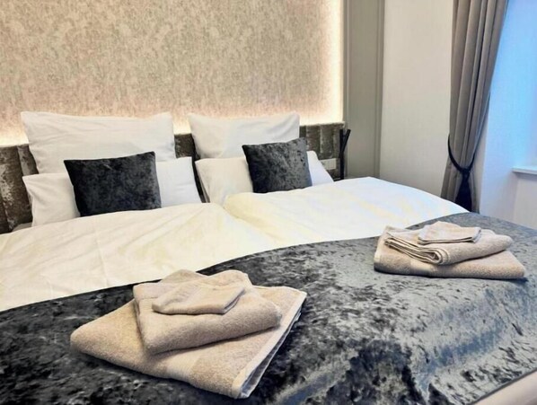 A neatly made bed with white linens and a marble headboard. There are two folded towels on the marble bedside table. - Feel good in the castle - your wellness break at Lake Constance (Stockach)