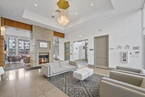 Eine moderne Lobby mit Kamin, Sitzgelegenheiten und einer Rezeption.