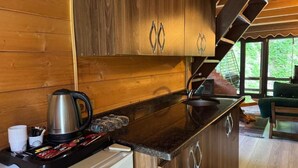 A kitchen with wooden cabinets, a stainless steel kettle, and a countertop. - Ayder Dağ Evleri Elizan (Camlihemsin)