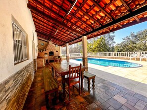 An outdoor patio with a pool, a brick oven, and a covered seating area. - Casa de Campo com Balan o na Rvore (Itapevi)