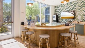 Een moderne keuken met een bar, grote ramen en een backsplash in een herringbone patroon.