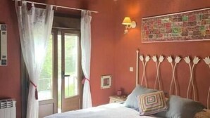 A bedroom with a bed, curtains, a wall-mounted lamp, and a window. - El Acebo de Tanarro (Sepúlveda)