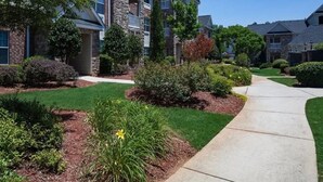A residential area with multi-story buildings, well-maintained lawns, and a clear pathway. - Landing | Stylish 2BD, Gym, Tennis Court (Stockbridge)