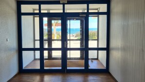 Ein Zimmer mit einer großen Glasdoor, die auf einen Balkon mit Meerblick führt.