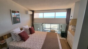 Ein Hotelzimmer mit Bett, Fenster mit Aussicht, Nachttisch und Beistelltisch.