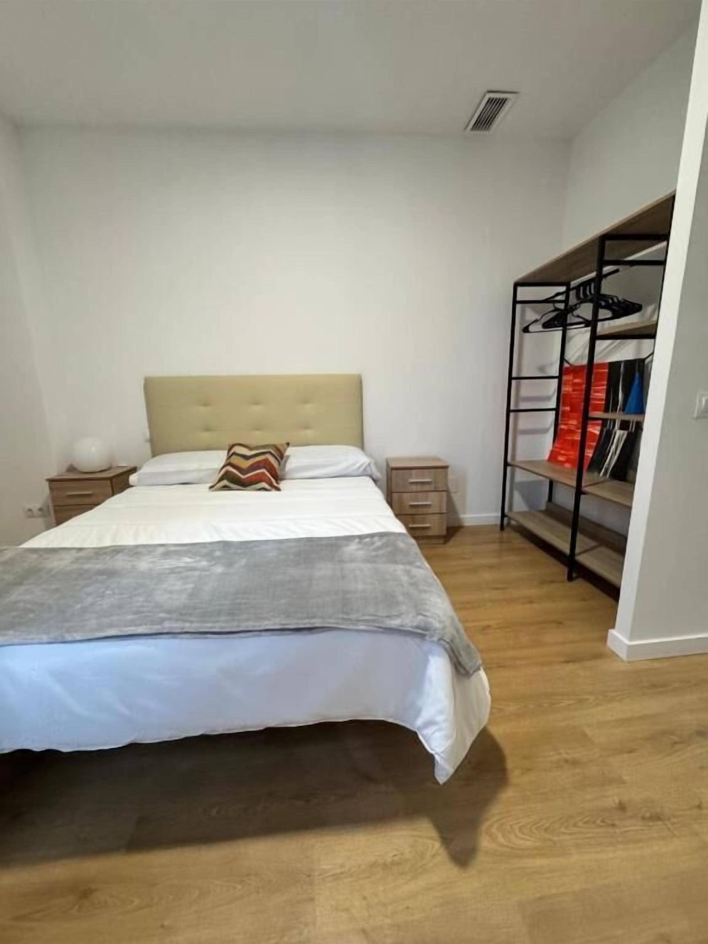 Une chambre à coucher comprenant un lit, une table de chevet, une commode, une armoire et un placard.