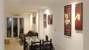 A dining area with a table and chairs, a sofa, and artwork on the walls. - Aires del Cerro House (Yerba Buena)