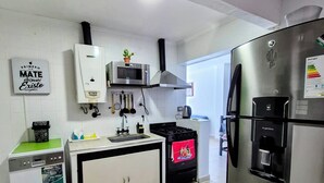 A modern kitchen with a built-in oven, microwave, and a large refrigerator. - Aires del Cerro House (Yerba Buena)