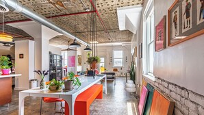 A spacious kitchen with a long counter, multiple chairs, and a variety of plants. - Bright and airy loft space 10 min walk from stadiums with private roof terrace (Atlanta)